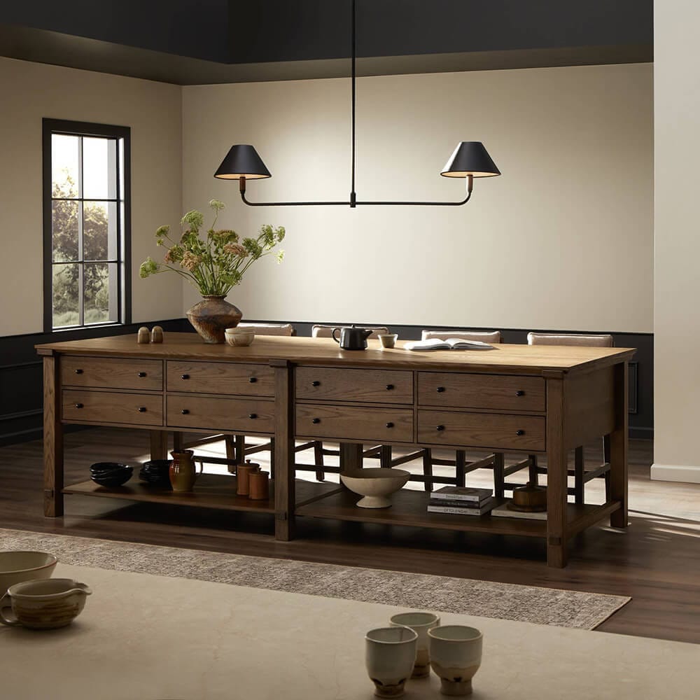 A beautiful wood kitchen island looks inspired by antique draping tables from the Victorian era. A clean modern chandelier updates the room.